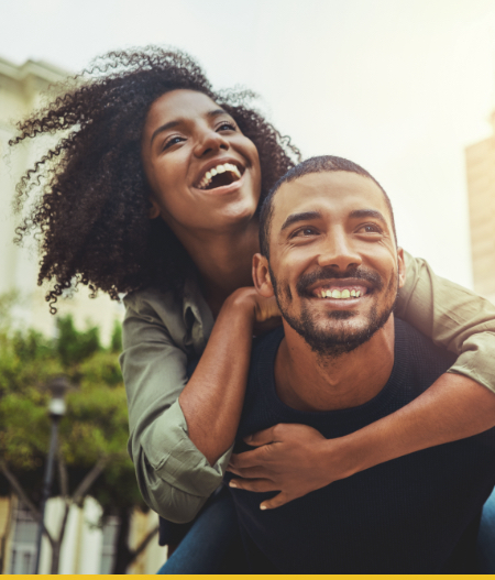 A joyful couple enjoying a playful moment outdoors