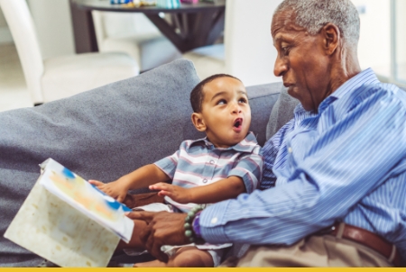 A joyful scene of a grandfather and his grandson sitting together on a couch