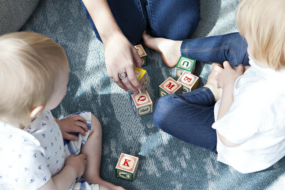 A mother and her two children playing with toys