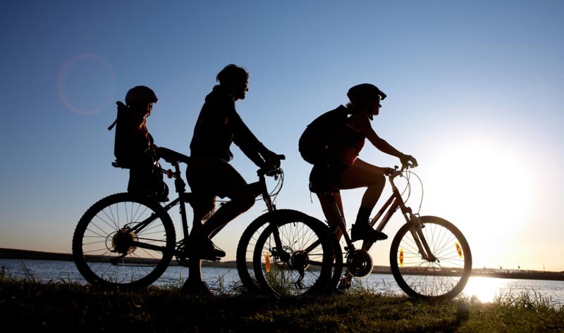 Two people biking with a child on board